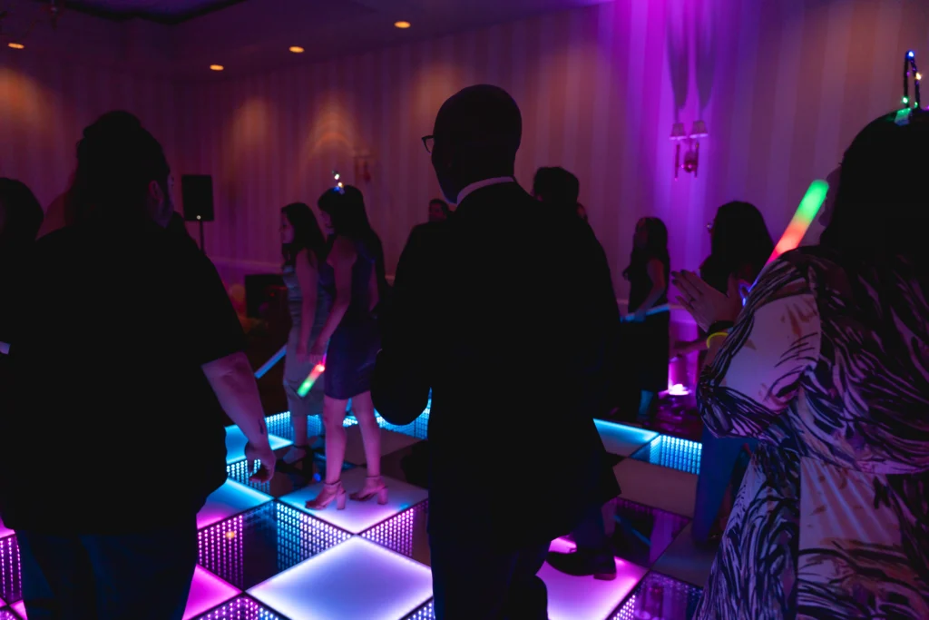 Guests enjoying a lively dance floor with colorful LED lights