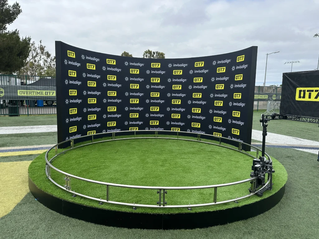 Outdoor event photo booth with a 360 setup and branded backdrop for engaging experiences.