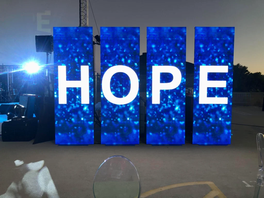 Large LED display spelling out 'HOPE' at a conference.