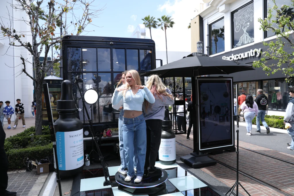 Young woman having fun on a event photo booth in a busy outdoor shopping area.