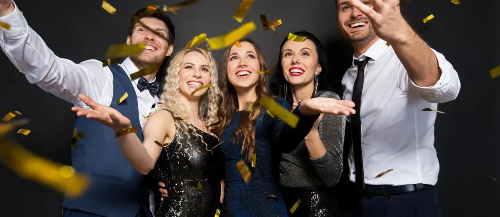 Group of professionals enjoying a confetti celebration at a photo booth.