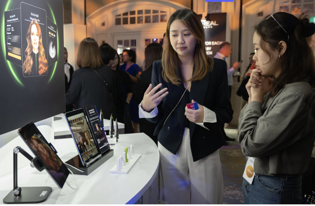 People engaging with L'Oréal’s virtual try-on technology at a corporate event.