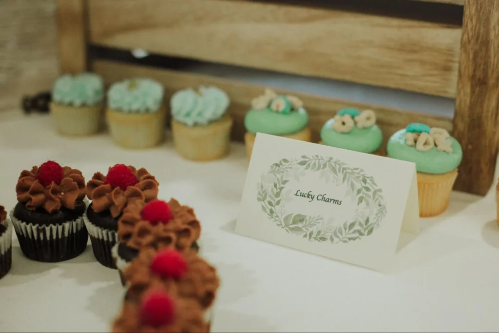 Assorted cupcakes with 'Lucky Charms' label at wedding.