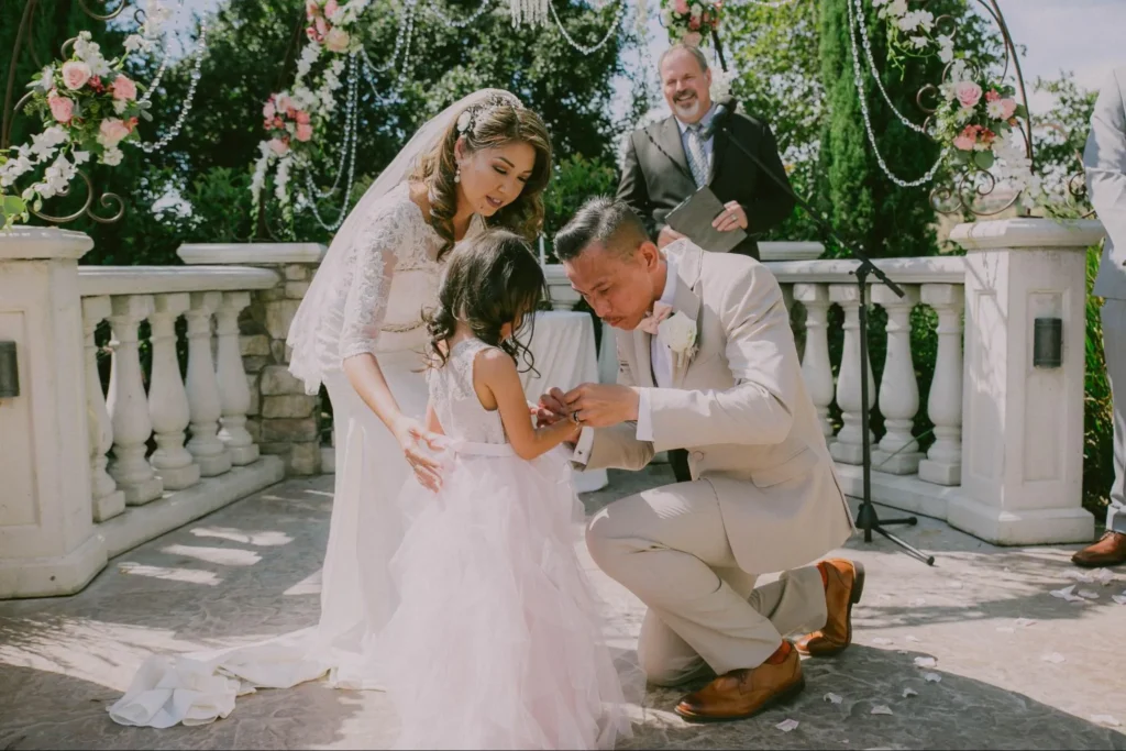 Bride and flower girl during outdoor wedding ceremony.