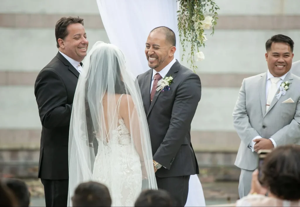 Bride and groom exchanging vows at an outdoor ceremony.