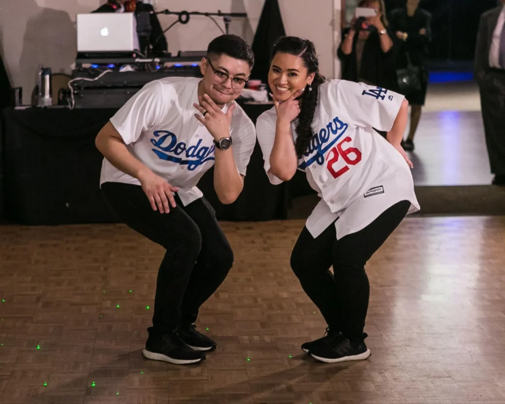 Couple in Dodgers jerseys dancing at wedding ceremony.