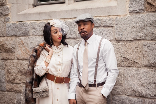 Elegant couple dressed in vintage-inspired wedding attire, showcasing timeless style.