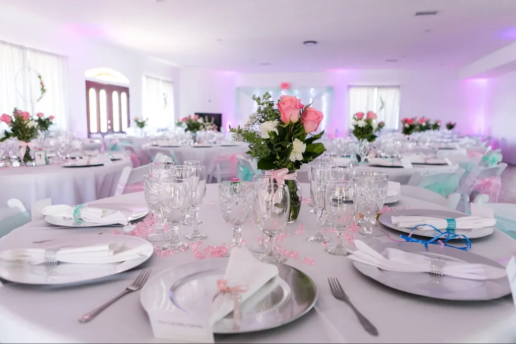 Elegant wedding table setup with pink floral centerpieces.