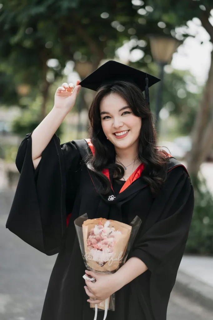 Graduate posing with diploma in cap and gown for a simple and elegant photo idea.