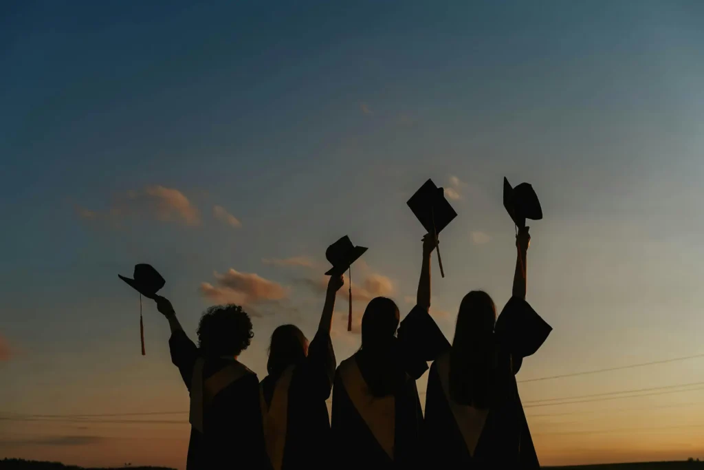 Graduating students celebrating their at sunset.