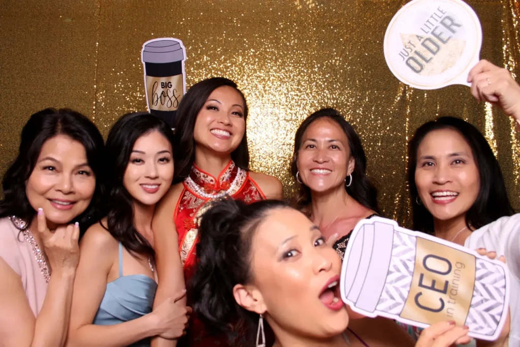 Group of guests posing with fun props at a photo booth.