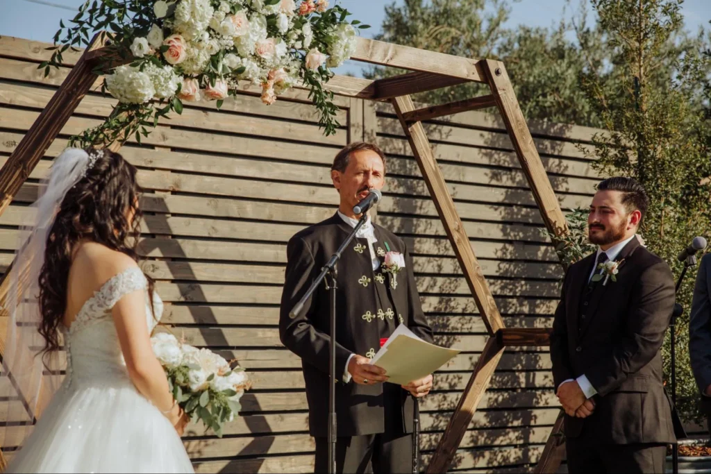 Officiant conducting wedding ceremony outdoors.