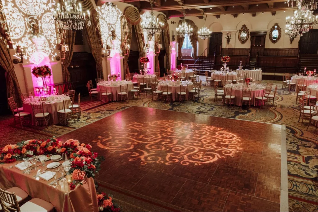 Ornate ballroom with floral lighting and elegant table settings.