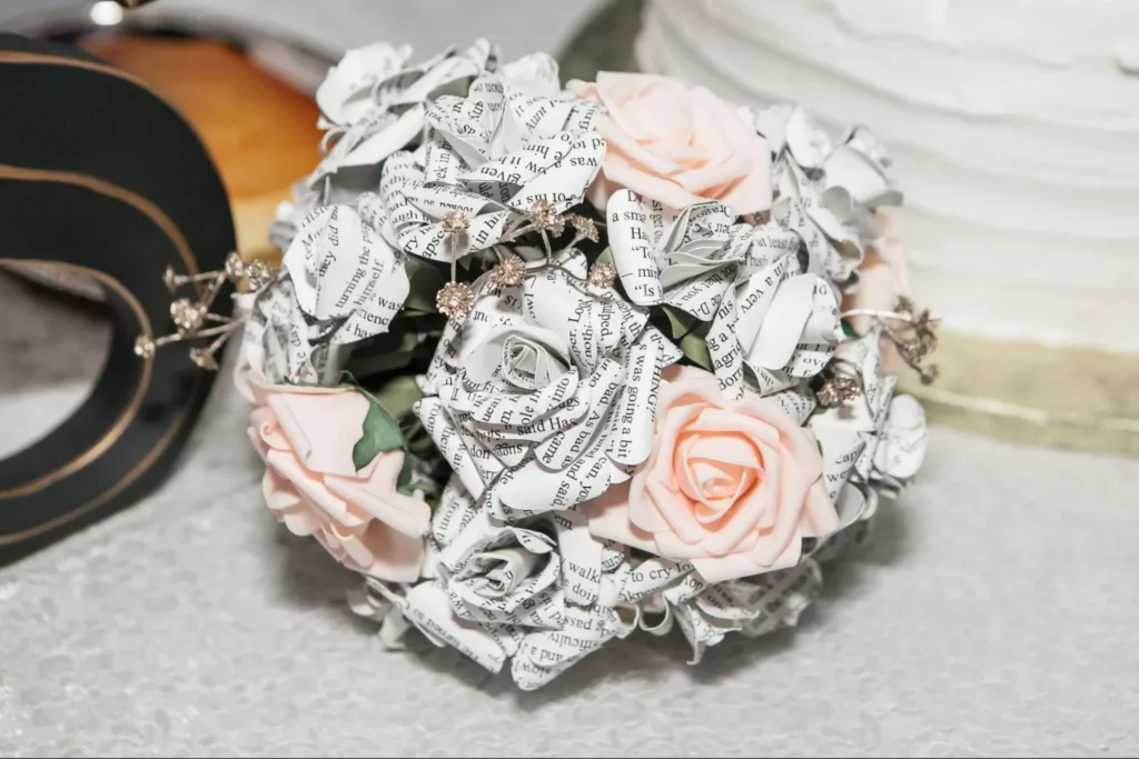 Unique wedding bouquet made of paper flowers and pink roses.