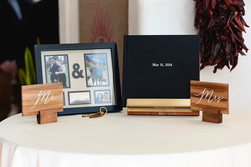 Wedding guest book and photo display on reception table.