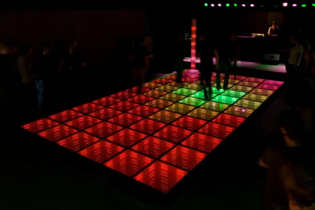 Rectangular LED dance floor glowing red and green, demonstrating standard dimensions for medium-sized events