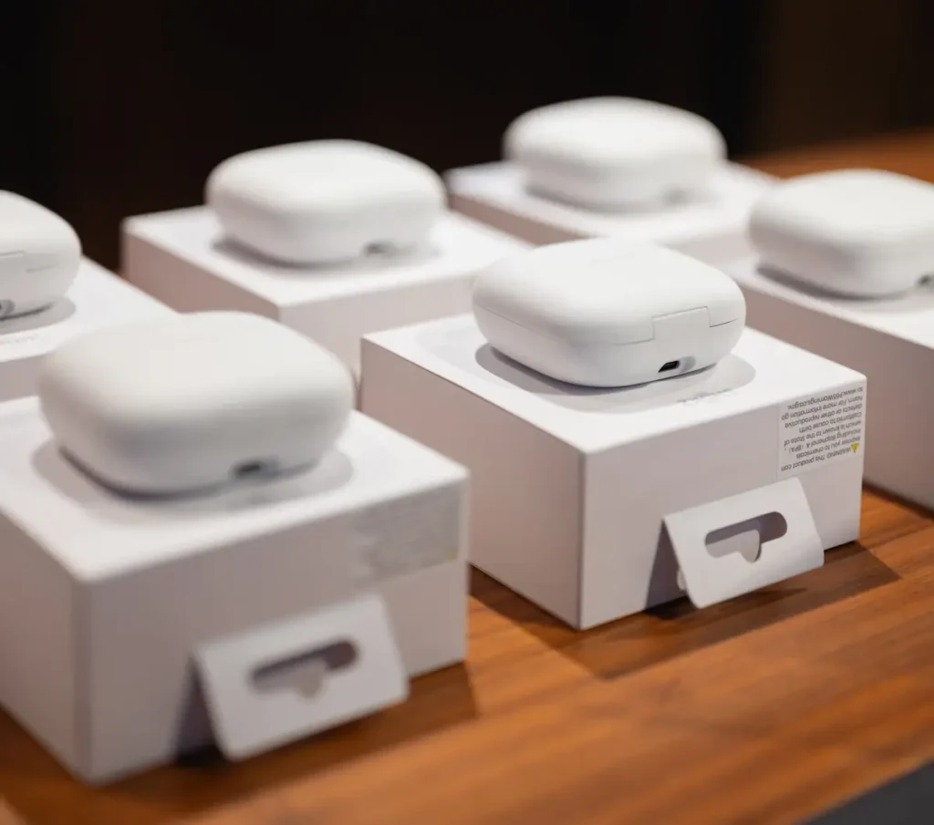 Rows of wireless Shokz earbuds in white cases displayed as raffle prizes