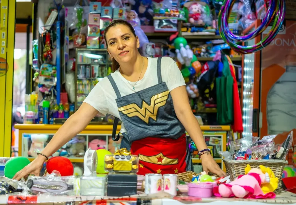 Birthday merchandise vendor managing colorful inventory display at event shop