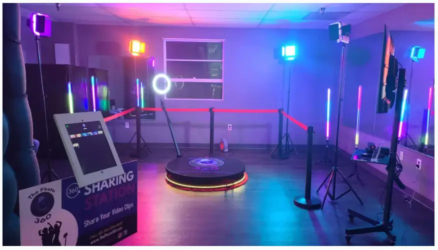 Professional 360-degree photo booth setup with illuminated platform and colorful lighting for event rentals