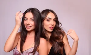 Image showing Two women with dark hair posing against plain background in professional studio photo booth setting