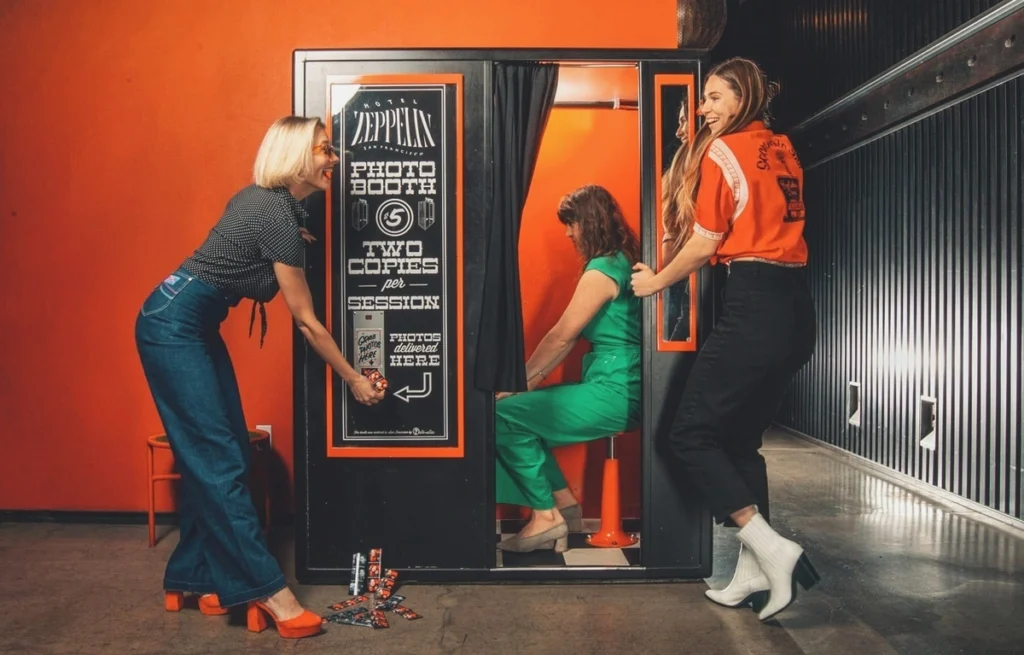 Vintage-style Hotel Zeppelin photo booth with women using retro booth that delivers two copies per session